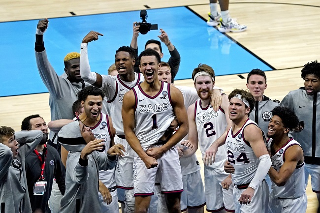 Against anyone Gonzaga faced in the Final Four, the Bulldogs were heavy favourites. But the Bulldogs prevailed in a historic nail-biter to move on past UCLA. Following a nail-biting finish to regulation, Gonzaga's Jalen Suggs sealed overtime with a buzzer-beating prayer, lifting the Bulldogs to a 93-90 victory and a date with Baylor in Monday's national championship game. Gonzaga's perfect season survives a thrilling finish. Johnny Juzang of UCLA knotted the game with 3.3 seconds remaining on a putback of his own miss in heavy traffic, seemingly setting up a second overtime. Suggs, though, received the inbounds pass, dribbled the ball past midcourt, and, seeing an opening way beyond the 3-point line, swished a shot from beyond Damian Lillard's 3-point range. Suggs seems to have already known it was good before the ball went off the backboard and into the net at the sound of the buzzer. Gonzaga barely made it through the regular season The Bulldogs survived a red-hot shooting performance from UCLA and a dramatic finish in the waning seconds of regulation to send the game into overtime. At the end of regulation, with the score knotted at 81, Juzang shook off a defender's screen and drove to the hoop. Drew Timme, who was already on the bench with four fouls, blocked Juzang's shot and forced a foul, saving a national championship for Gonzaga. The National Championship Game will include the top two ranked teams. Gonzaga, who had won its previous 27 matches by double digits, almost avoided defeat. On December 2nd, Gonzaga faced its most serious test since a win over West Virginia by a score of 87-82. But Gonzaga passed the test and will now face Baylor, who crushed Houston in the second national semifinal on Saturday. After a surprising run through the tournament, the best two teams in the country will face off for the national title. The Bruins, who are considered to be underdogs, present a formidable challenge for the Zags. Despite Suggs and likely fellow lottery pick Corey Kispert going scoreless for the first 8:44 of the game, UCLA came out swinging, racing to a 17-13 lead. The Bruins had a nearly perfect offensive first half, shooting 57.7 percent from the field and 57.1 percent from outside the arc while committing just five turnovers. However, they went into the locker room down as Kispert's jumper with 0.4 seconds to capped an equally spectacular Gonzaga half and gave the Bulldogs a 45-44 lead. UCLA, despite being a No. 11 seed, did not fold in the second half and kept fighting against the finest team in the country. For UCLA, Juzang was the driving force, capping off a scorching tournament with a 29-point performance that brought the Bruins dangerously close to pulling off another upset. The Bulldogs, though, were not going to be denied their chance at history. Timme and Ayayi sped Gonzaga to victory. While Suggs and Kispert had a rough start, UCLA's early success was neutralised by Joel Ayayi. The junior guard started the scoring for Gonzaga and finished with 26 points and six rebounds. Timme led the Bulldogs with 25 points and took the charge that ultimately saved their season as the Bruins hung close in the second half. Timme was Gonzaga's most reliable weapon, hitting 11-of-15 from the field on a night when the Kispert struggled from 3-point range (2-of-8). In crucial moments, Suggs always delivers. Suggs, however, didn't start scoring until there was 7:25 left in the first half since he was held scoreless before then. Plus, he contributed two plays to the annals of NCAA tournament history. If not for a miraculous comeback in the waning seconds of regulation, he might not have had a shot at his game-winning goal. It was knotted at 77 when 6-9 UCLA forward Cody Riley went for a slam. This wasn't going down well with Suggs, a 6-4 guard. When Riley attempted a dunk, Suggs was there to block it, grab the offensive rebound, and then find Timme for a fast-break layup with a precise bounce pass through the crowd. A performance like that would guarantee Suggs a high draught pick in the NBA this summer. While this may change in the future, Suggs is currently focused on immortality. The suddenly 31-0 Bulldogs are one win away from being the first college basketball team to go unbeaten from the start to the finish of the season since Indiana's 1976 championship run.